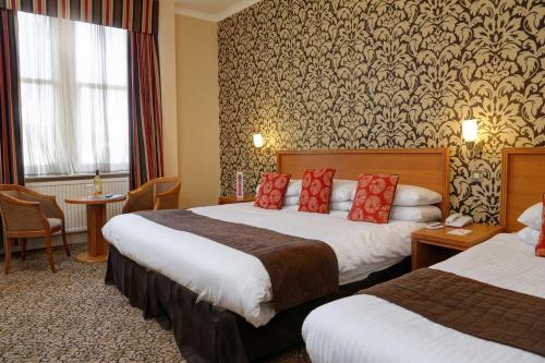 邓迪贝斯特韦斯特皇后酒店酒店的酒店客房 - 带两张带红色枕头的床