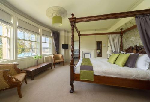 埃文河畔布拉德福Leigh Park Country House Hotel & Vineyard, BW Signature Collection的一间卧室配有一张天蓬床和一把椅子