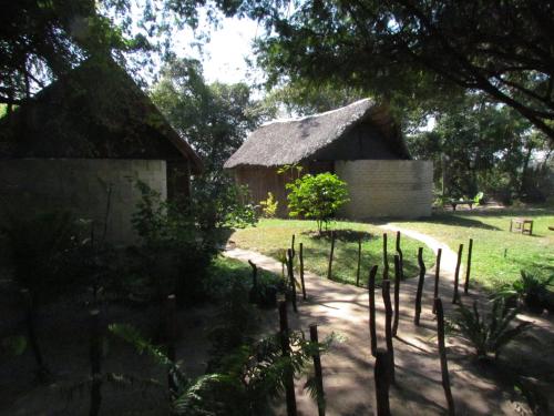 卡蒂马穆利洛Caprivi Houseboat Safari Lodge的庭院中茅草屋顶的房子