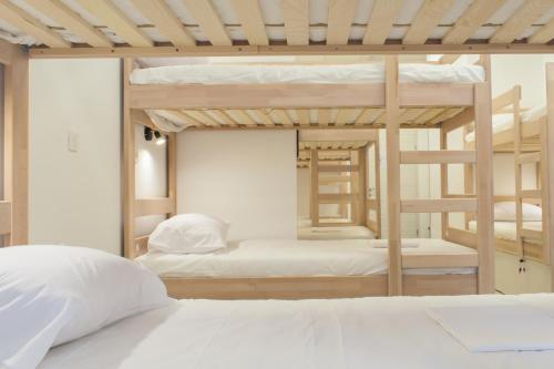 斯普利特Gravitas Hostel的卧室配有2张双层床和白色枕头