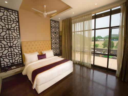 钦奈ST Parklane Airport Hotel Chennai的一间卧室设有一张床和一个大窗户