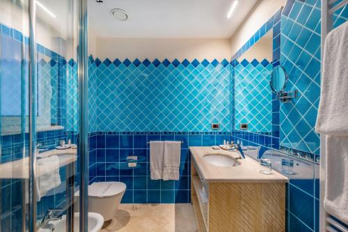 切尔沃港佩特拉比安卡酒店的蓝色瓷砖浴室设有卫生间和水槽
