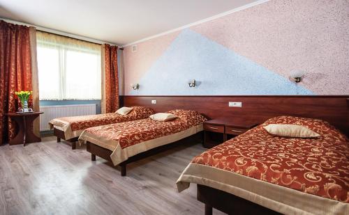 卢布林Hotel Irys的酒店客房设有两张床和大窗户。