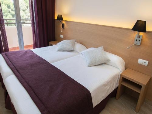 圣米格尔港Apartamentos San Miguel Park & Esmeralda Mar的酒店客房设有两张床和窗户。