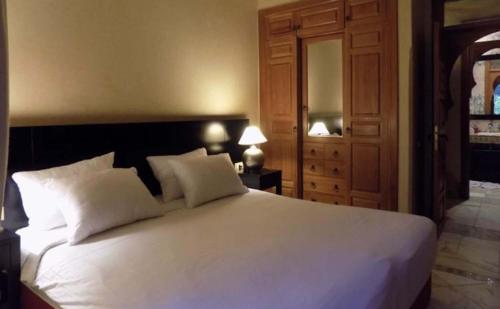 马拉喀什Palmeraie village的卧室配有一张带两个枕头的大白色床