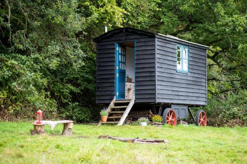 RakeBeautiful, Secluded Shepherd's Hut in the National Park的坐在田野顶上的黑色小房子