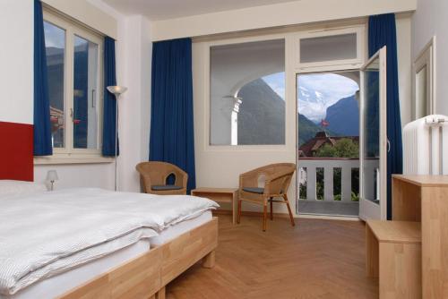 因特拉肯马腾霍夫度假村酒店的一间卧室设有一张床和一个大窗户