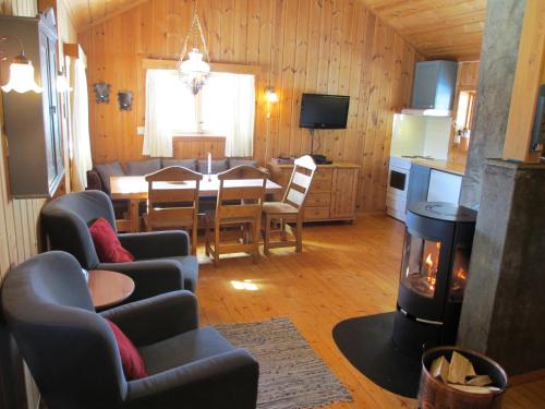 TuddalHogstul Hytter - Skojestua - 2 Bedroom Cottage的客厅配有餐桌和壁炉