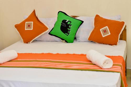 康提Kandy Dilruk Homestay的一张带橙色和绿色枕头的床