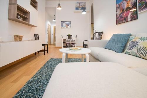 马拉加Family apartment Patio&Swimming pool in center Malaga的客厅配有白色的沙发和桌子