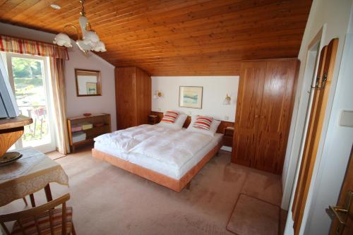 赖弗尼茨Haus Wolfgang的一间卧室设有一张床和木制天花板