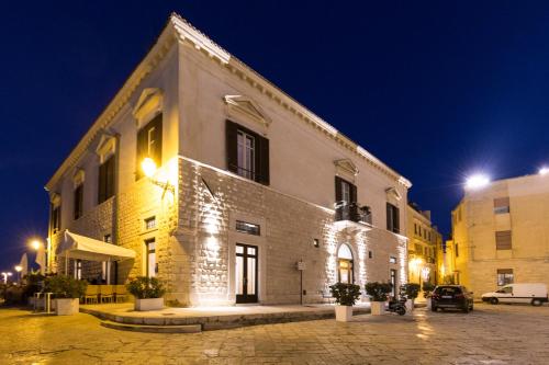 特拉尼Palazzo Filisio - Regia Restaurant的一座白色的大建筑,晚上有灯光