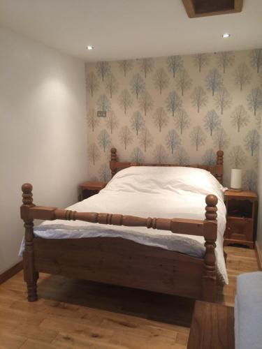 曼彻斯特The Old Vicarage Lodge的一间卧室配有一张木架床