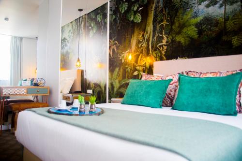 托马尔Thomar Boutique Hotel的一间卧室配有一张带绿色枕头的大床