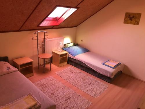 伦蒂Vadvirág vendégház的一间卧室设有两张床、一张桌子和一个窗口。