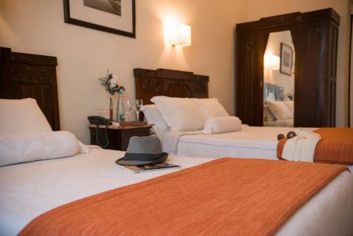 波尔图阿利多斯酒店的一间设有两张床的房间,上面有一顶帽子