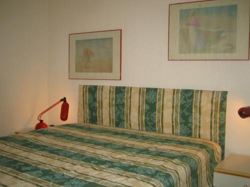 拉帕洛Residence Portofino Est的一间卧室配有一张带毯子和灯的床