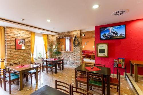 Vrbovec弗尔博韦茨酒店的一间带桌椅和红色墙壁的餐厅