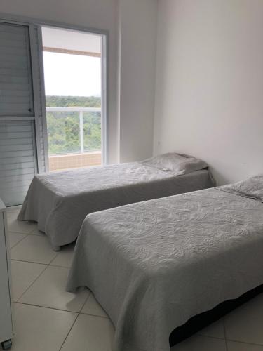 圣劳伦斯海滨Condominio Reserva da Mata - Riviera de São Lourenço的白色客房的两张床,设有窗户