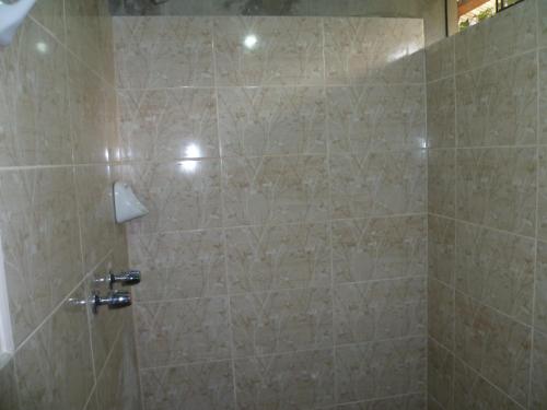 奥克萨潘帕HOSPEDAJE CAMPOS ELÌSEOS的浴室设有米色瓷砖和淋浴。