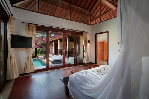 塞米亚克总理酒店集团巴厘岛总理别墅的一间卧室配有一张床,享有游泳池的景色