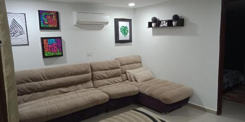 峇六拜纳德拉小屋民宿的一间客厅,客厅内配有棕色沙发