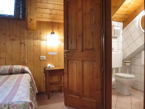 科涅Hotel Locanda Grauson的浴室设有床、卫生间和门。