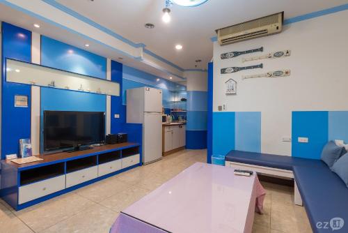 高雄米果的家 的客厅设有蓝色的墙壁、沙发和电视