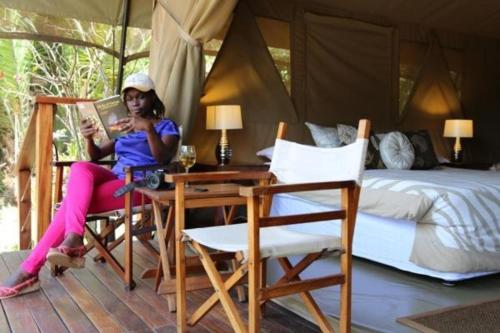 内罗毕牛羚生态帐篷营地的坐在卧室桌子上的女人