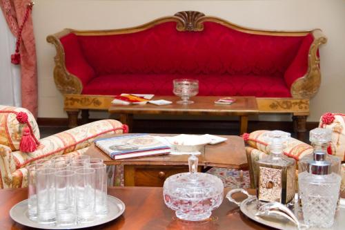 阿斯科利皮切诺阿斯科利皮切诺秘密花园酒店的客厅配有红色的沙发和桌子