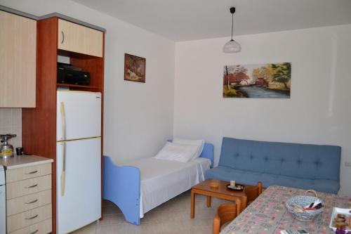 DhorizátaSpacious 1 bedroom apartment 2 km to Pessada beach的厨房配有蓝色的沙发和桌子