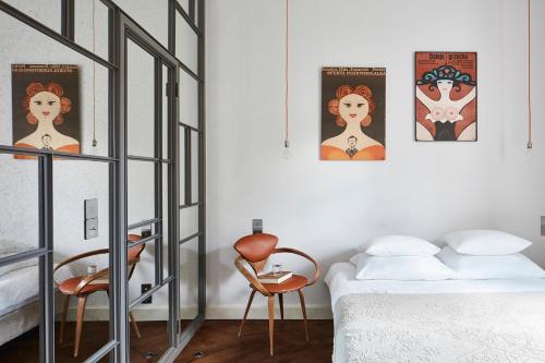 华沙我们住宿加早餐酒店的卧室配有一张床和墙上的两张海报