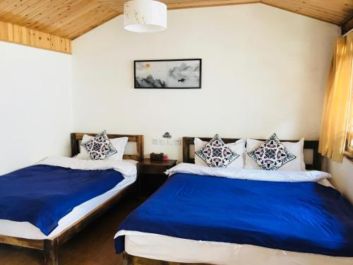 剑川县剑川沙溪游子闲庭客栈的蓝色和白色的客房内的两张床