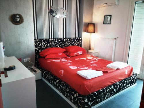 雅典Greek hospitality 2的一间卧室配有红色的床和红色枕头