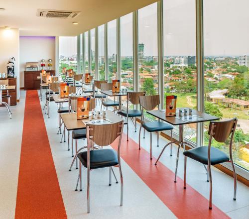 圣克鲁斯LP艾奎佩特罗酒店的餐厅设有桌椅和大窗户。