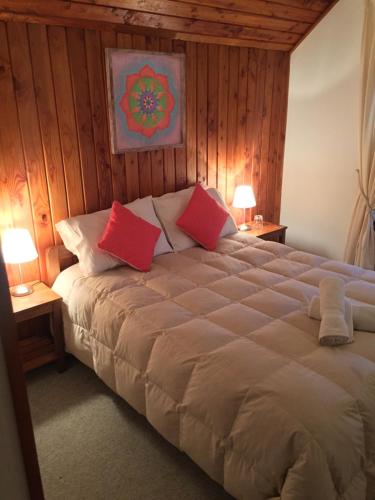 比亚里卡Hostería Bilbao的一间卧室配有一张带红色枕头的大床