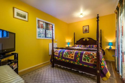 KaiapoiCavendish Farm的一间卧室设有床铺、电视和黄色的墙壁