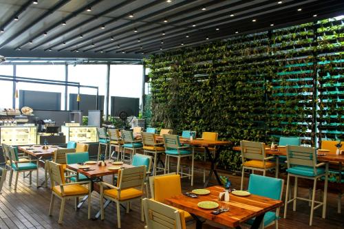 孟买伊姆普瑞萨酒店的餐厅设有桌椅和葡萄酒瓶壁