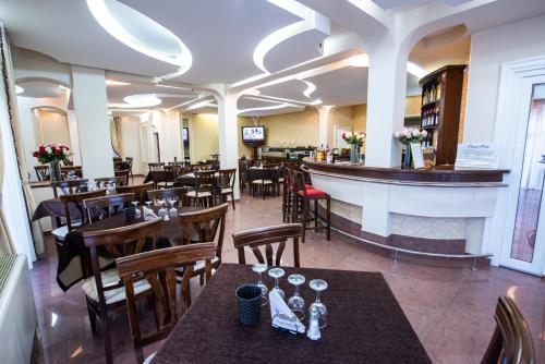 蒂米什瓦拉帝国高级酒店的一间带桌椅的餐厅和一间酒吧