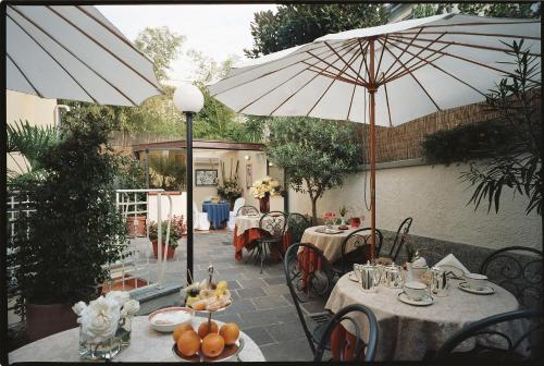 米兰迪耶奇酒店的花园内带桌子和遮阳伞的庭院