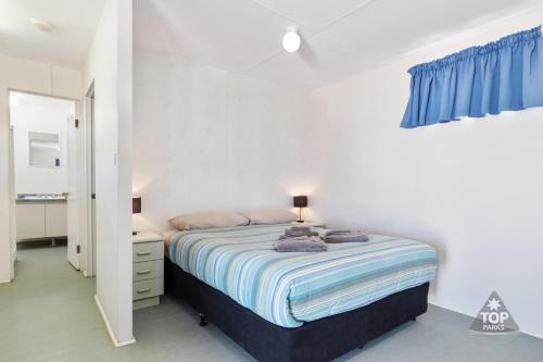 德纳姆Tasman Holiday Parks - Denham Seaside的白色卧室配有床和蓝色窗帘