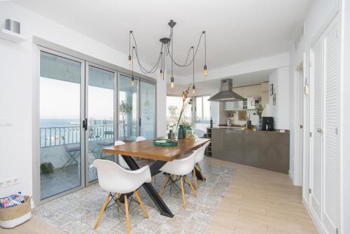 阿利坎特Alicante Ocean View的厨房配有木桌和白色椅子