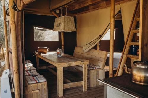 Valle de AbdalagísCortijo Dos Santos的帐篷内带桌子和床的房间