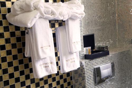 布拉柴维尔Hotel Amaritsah的浴室的墙壁上挂着白色毛巾