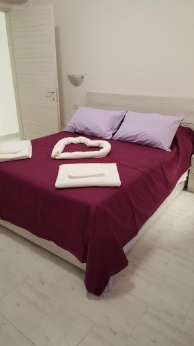 赫拉弗多纳CA' VEGIA的一张大床,上面有紫色的床单和毛巾