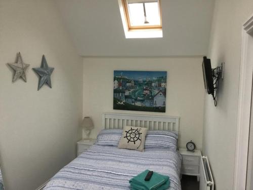 GourdonSma Harbour Hoose的卧室配有一张床,墙上挂着两颗星