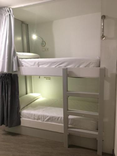 吉塔里亚Hostel Getaria的带镜子的客房内的两张双层床