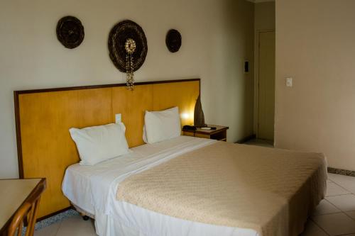 阿拉卡茹维亚马普拉亚依酒店的一间卧室配有一张大床和木制床头板
