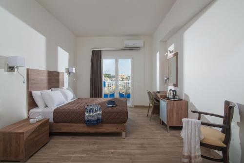 阿齐亚佩拉加Belvedere Village的一间酒店客房,一间设有一张床和一张书桌