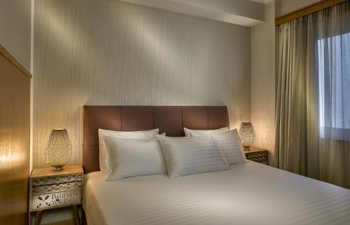 雅典Acropolis View Penthouse的卧室配有带白色枕头的床和窗户。